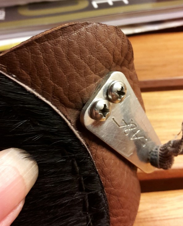 Close up of the securing screws, the elastic is knotted through a hole in the metal plate